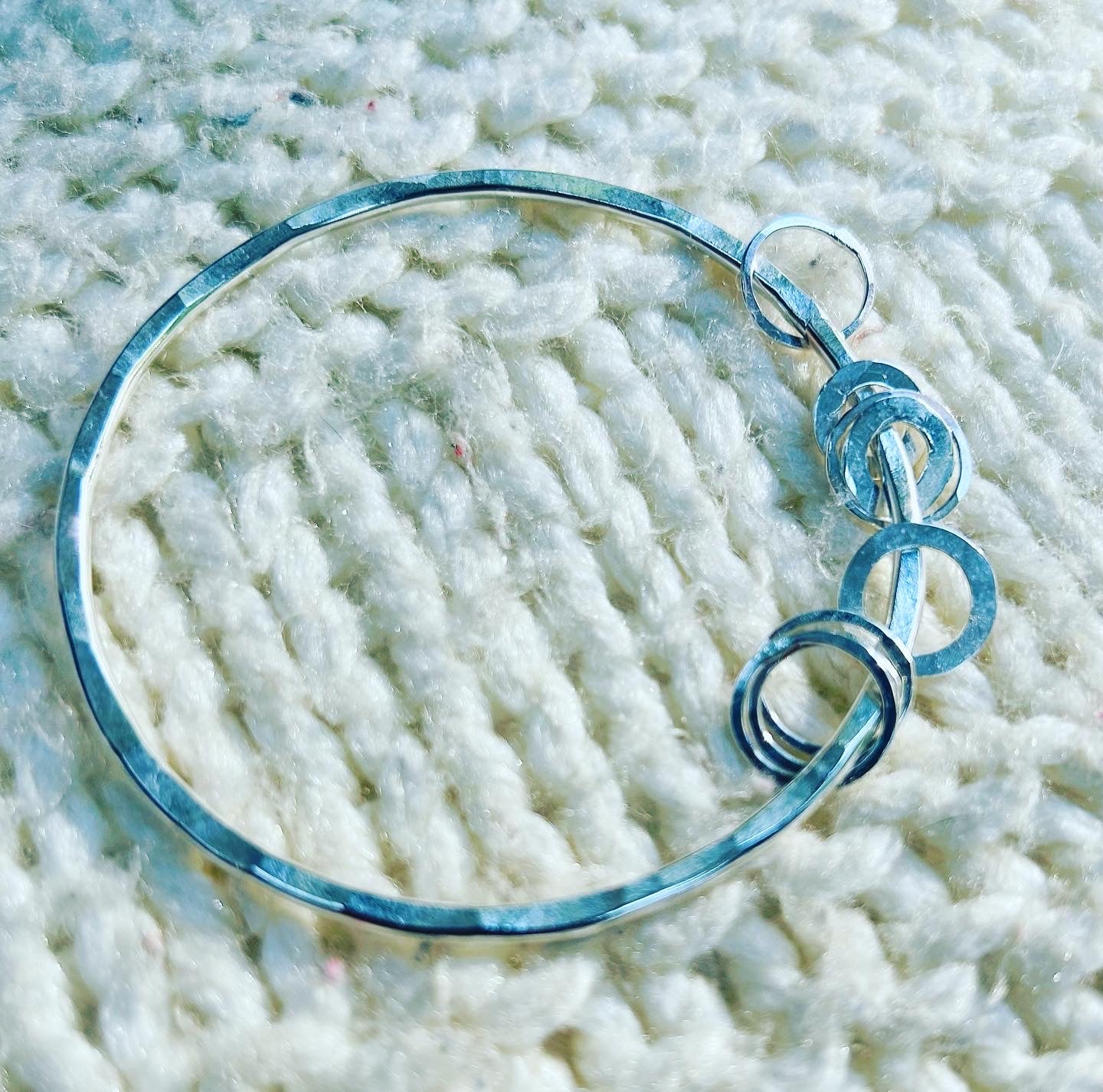 Hammered bangle with multiple silver hoop charms