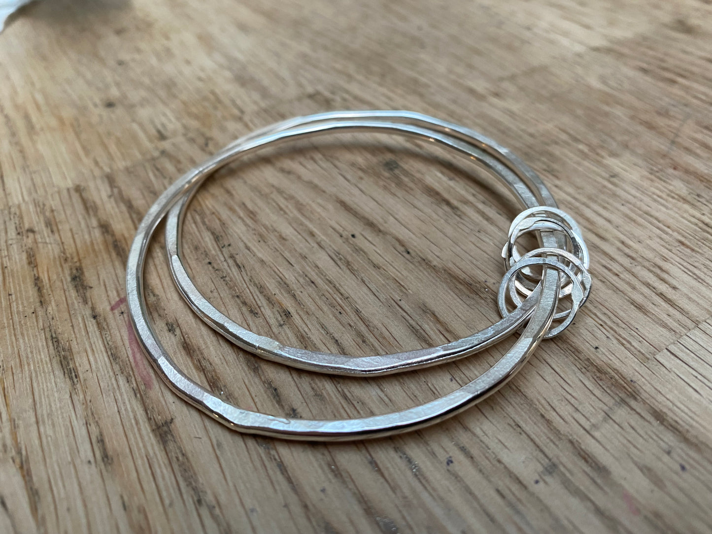 Hammered bangle with 5 silver hoop charms