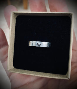 Hammered silver ring with heart detail.